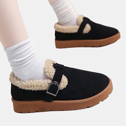 Black fleece-lined ankle boots with side buckle strap and textured lug sole