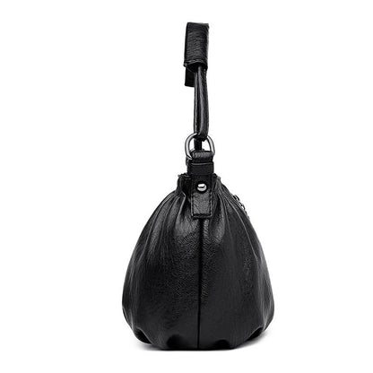 Black multi-layer handbag bottom view with short loop handle and gathered body shape