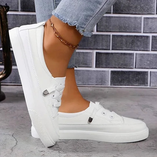White low-top orthopedic sneakers with lace-up front and thick cushioned sole