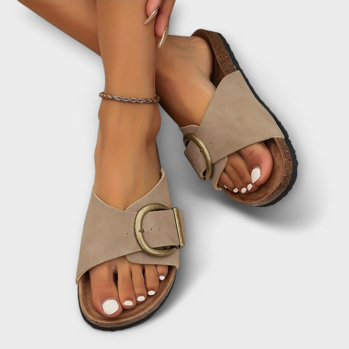 Orthopedic sandals in beige with adjustable ankle strap and round buckle over cork footbed.