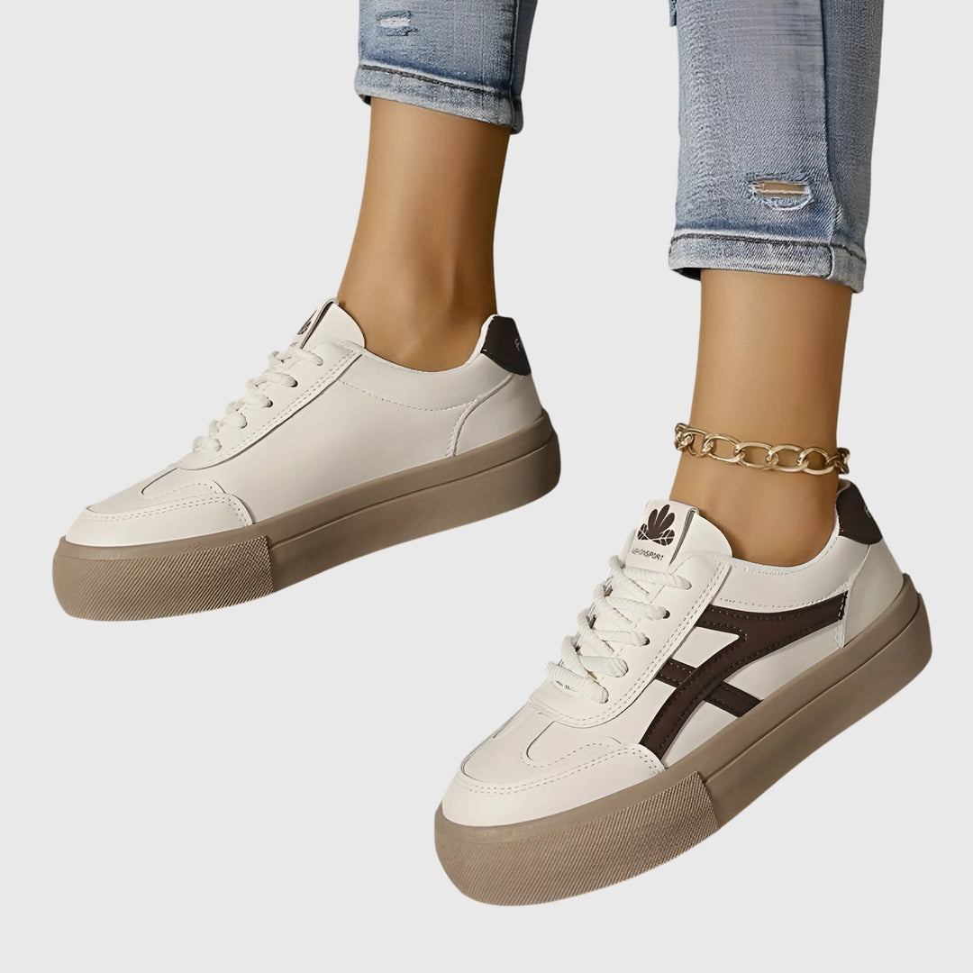 White orthopedic sneakers with dark brown stripes and tan platform sole, side view