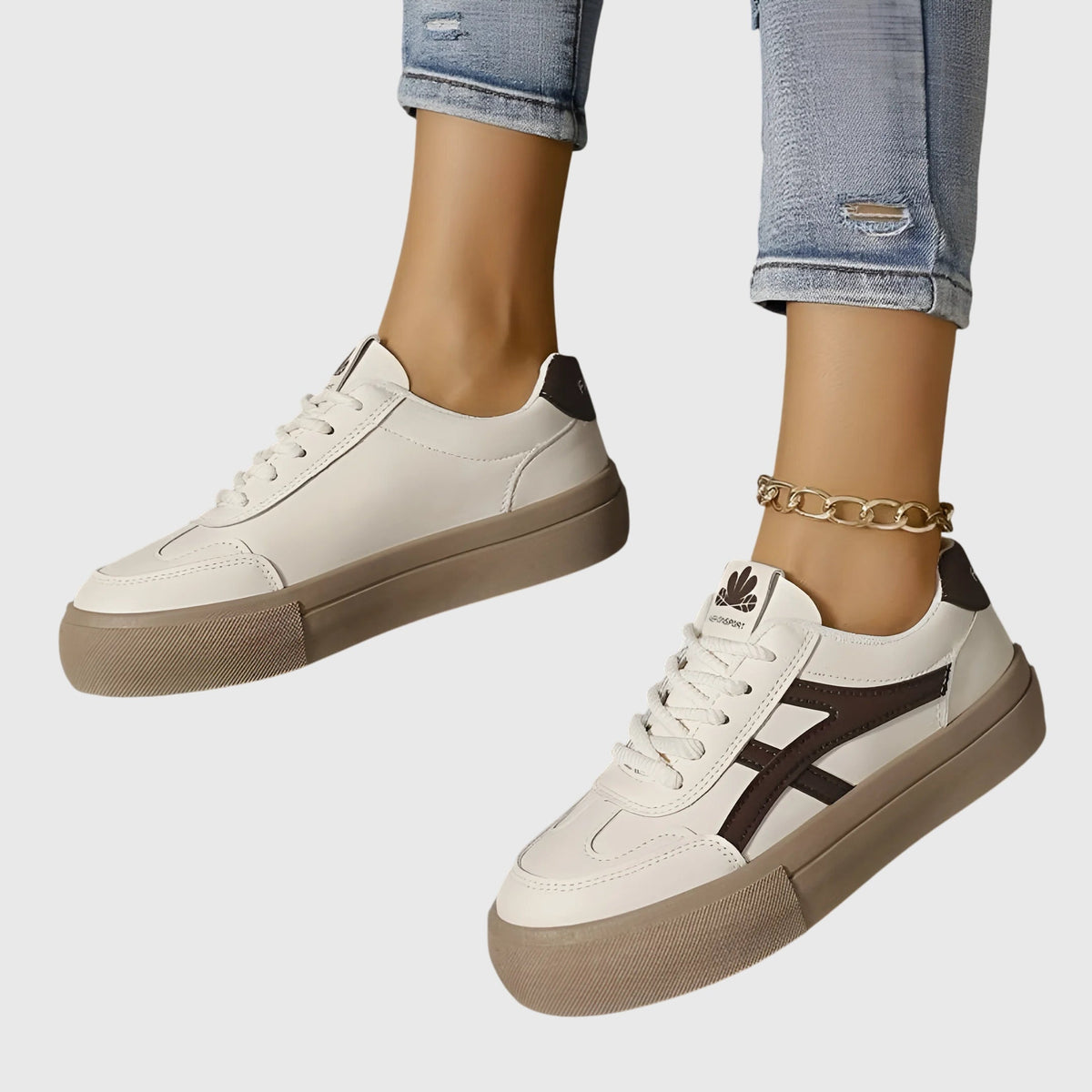 White orthopedic sneakers with dark brown stripes and tan platform sole, side view