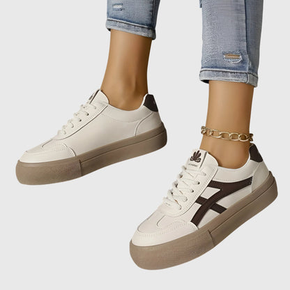 White orthopedic sneakers with dark brown stripes and tan platform sole, side view
