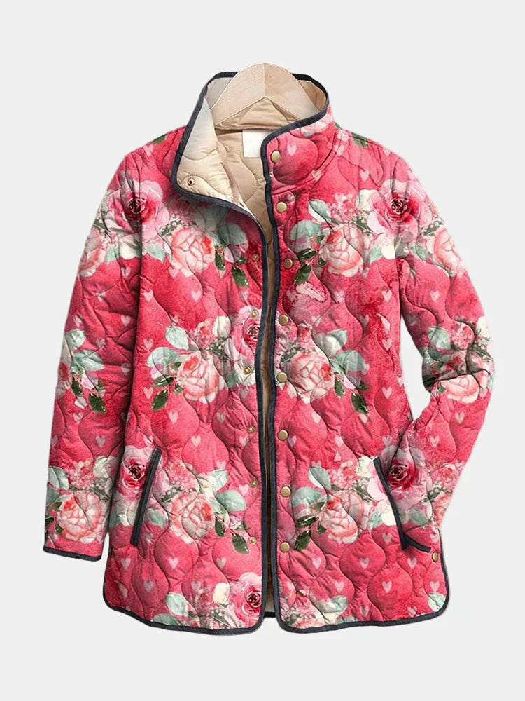 Pink floral quilted jacket with stand collar, front zip, and dark trim, buttoned pockets.