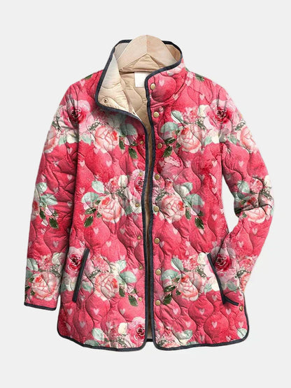 Pink floral quilted jacket with stand collar, front zip, and dark trim, buttoned pockets.