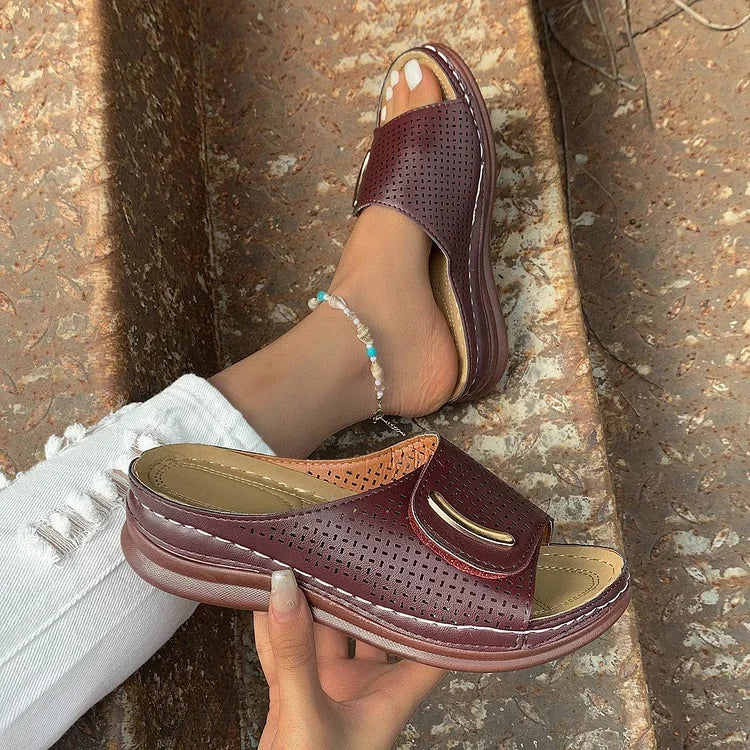 Burgundy perforated mule-style sandals with curved strap and cushioned footbed