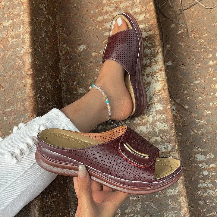 Burgundy perforated mule-style sandals with curved strap and cushioned footbed
