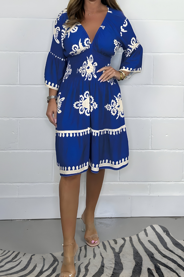 Royal blue knee-length dress with white embroidered florals and tassel-trim hem