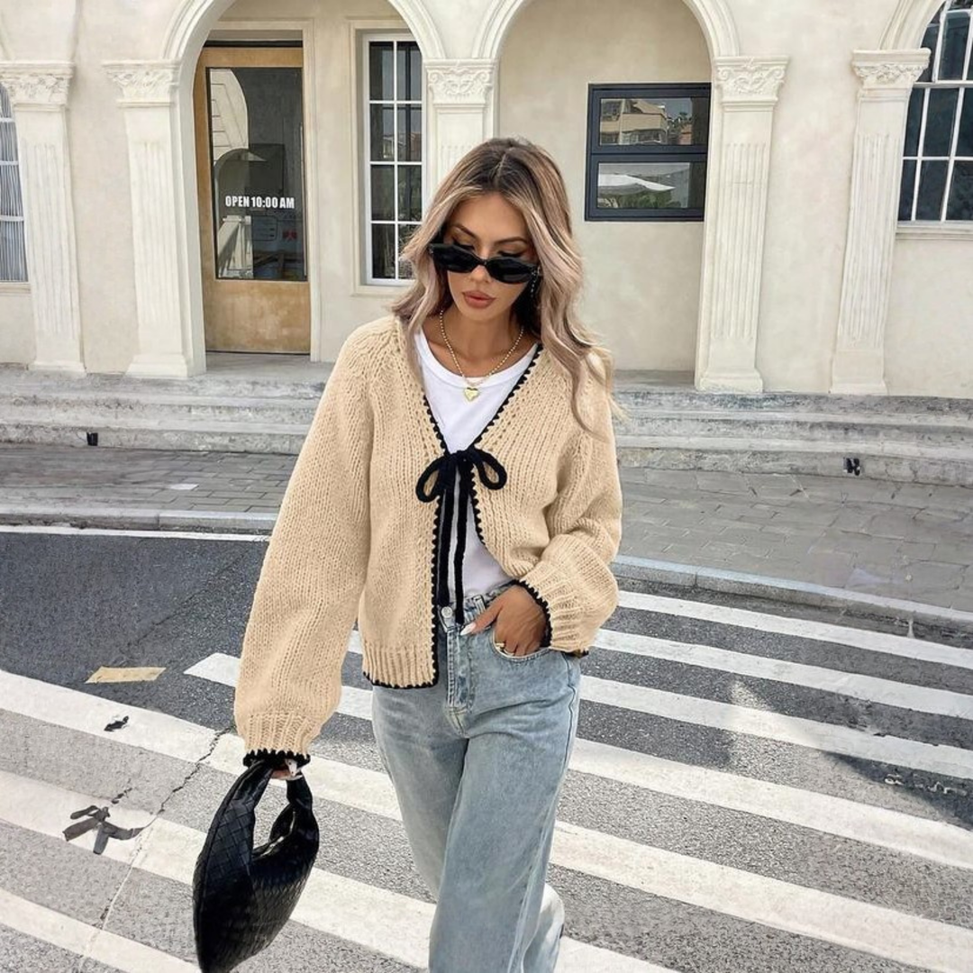 Cream knit cardigan with front tie and long sleeves, ribbed cuffs and hem.
