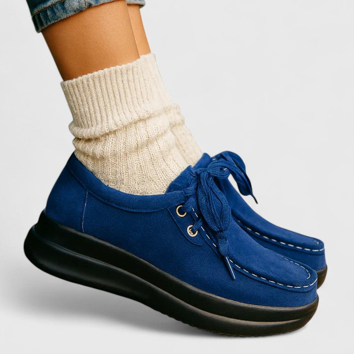 Blue lace-up orthopedic shoe side view with suede upper and thick dark sole.