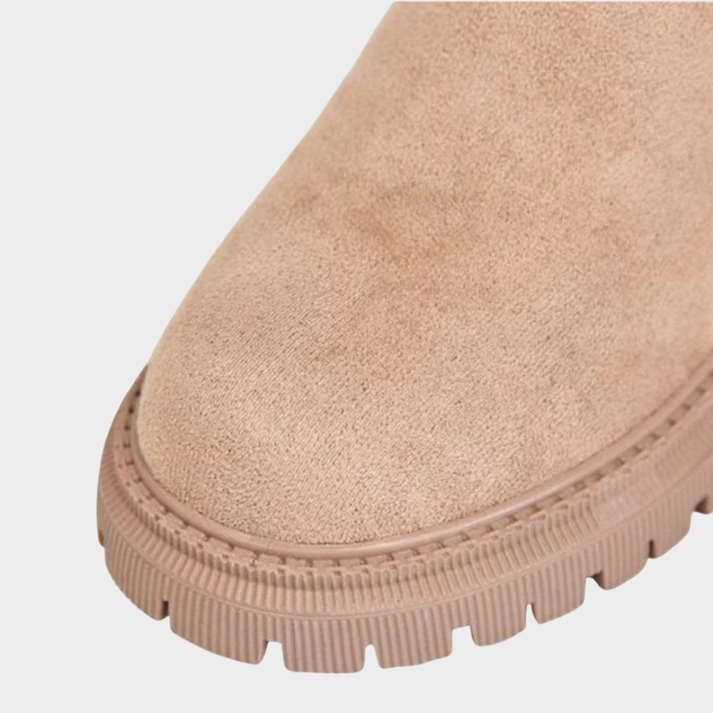Beige comfort boot outsole close-up with ribbed edge and textured tread