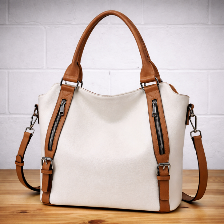 White leather hobo tote bag with tan accents, dual zip pockets, and two shoulder straps