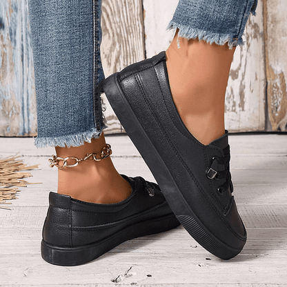 Black lace-up orthopedic sneakers with adjustable strap and grippy outsole