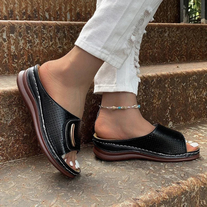 Black perforated slip-on sandals with curved metal-look bar detail