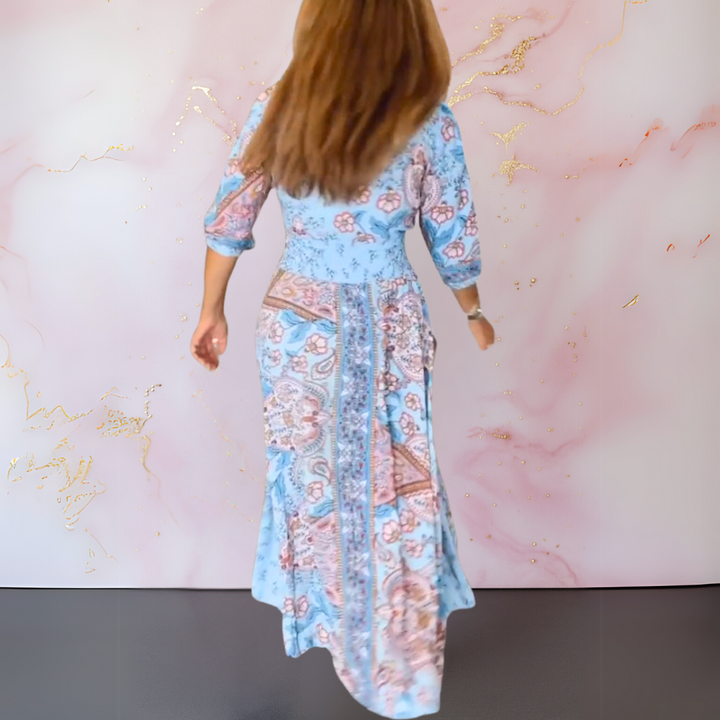 Blue paisley long summer dress, back view, V-neck placket, gathered waist, flared hem.