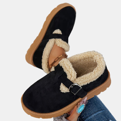 Black fleece-lined ankle boots with front strap buckle and tan-brown outsole