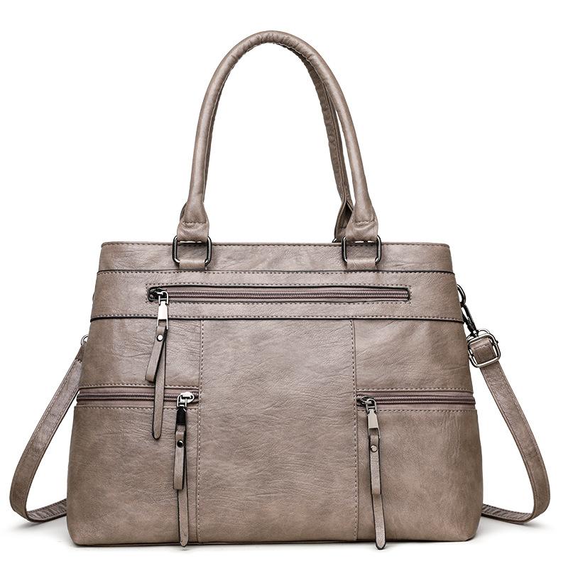 Grey leather women’s tote bag with double top handles, front zip pockets and crossbody strap