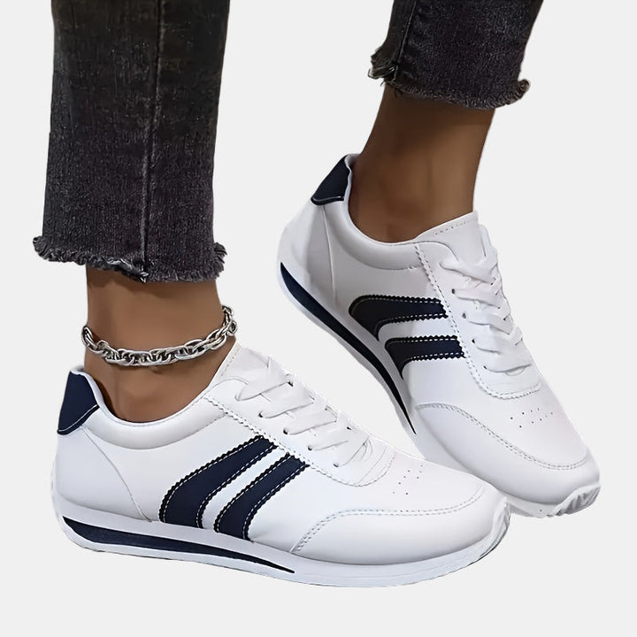 White orthopedic sneakers with navy heel panels, lace-up and sculpted sole