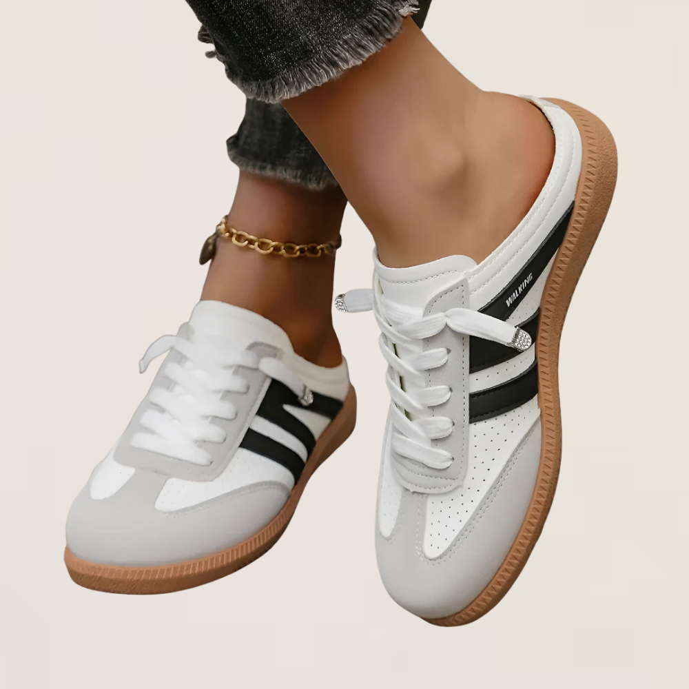 White retro sneakers with black side stripes and gum sole, side view.