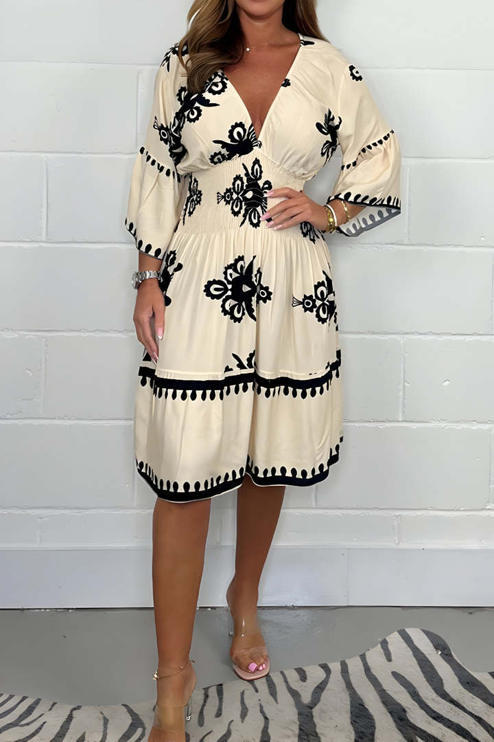 Cream knee-length dress with black embroidered florals and tassel-trim hem