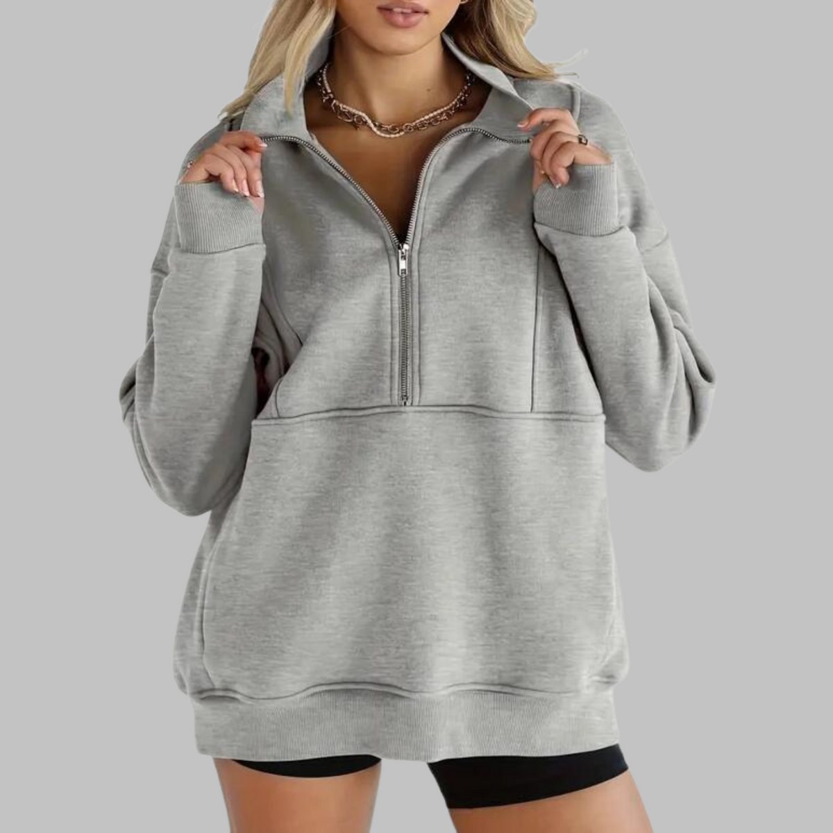 Gray oversized half-zip sweatshirt with front zipper and kangaroo pocket, ribbed hem