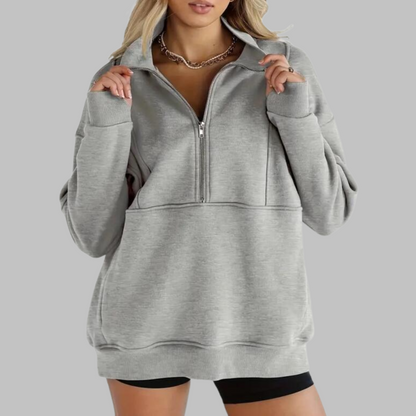 Gray oversized half-zip sweatshirt with front zipper and kangaroo pocket, ribbed hem