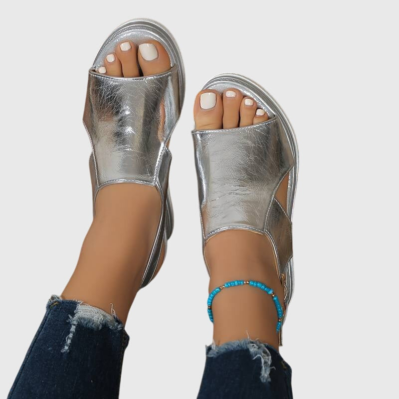 Silver metallic orthopedic sandals with open toe and ankle strap, side view