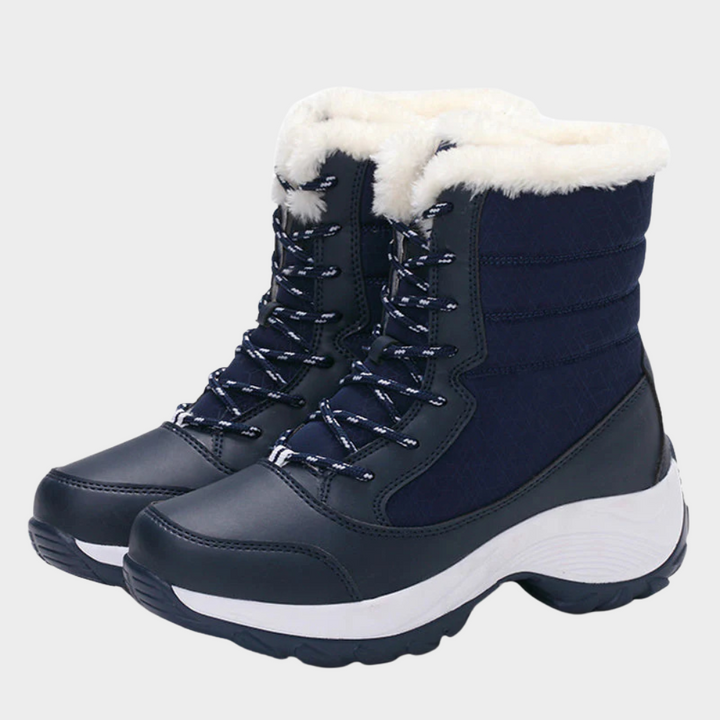 Navy winter boots with lace-up front, white faux-fur collar, and chunky tread sole.