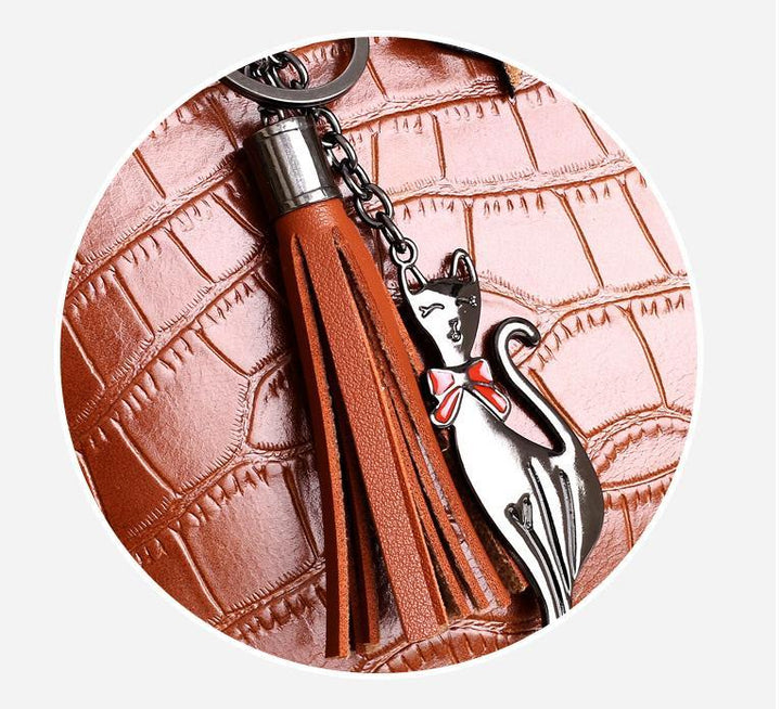 Brown croc-pattern tassel and cat charm detail on handbag hardware