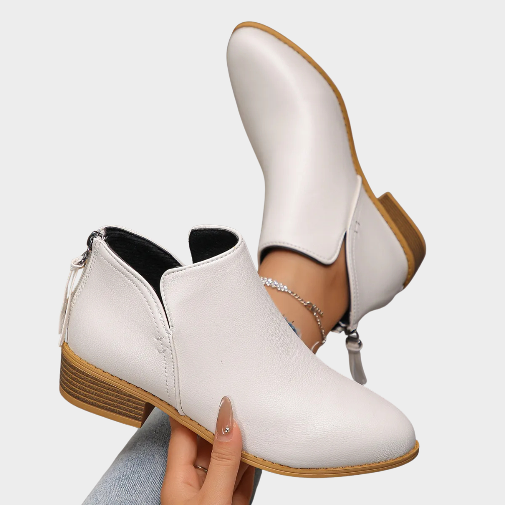 White ankle boots with low block heel, side zipper, and small pull tab