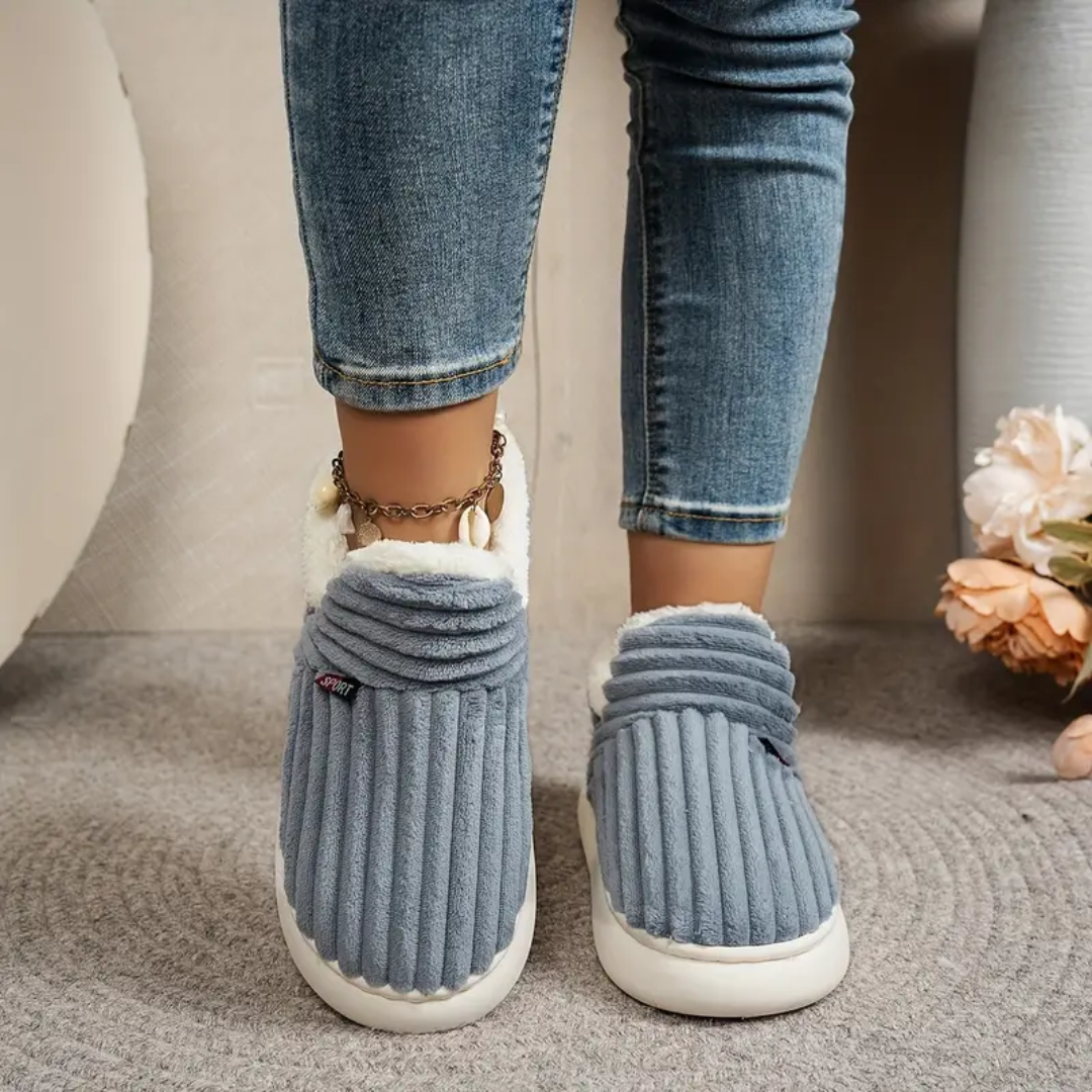 Grey comfort slippers with ribbed knit texture, white trim, and matching chain detail