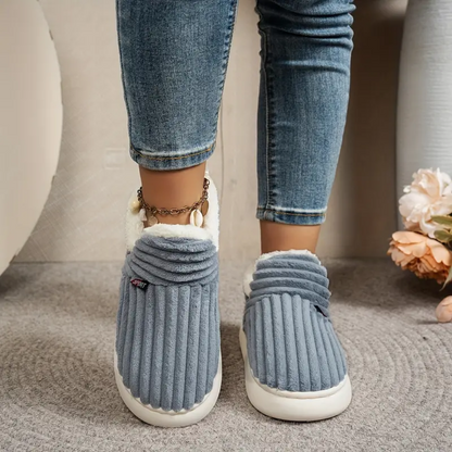 Grey comfort slippers with ribbed knit texture, white trim, and matching chain detail