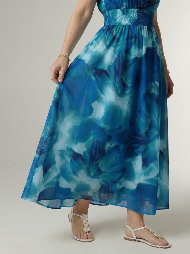 Blue gathered halter midi dress close-up of smocked waist and patterned skirt