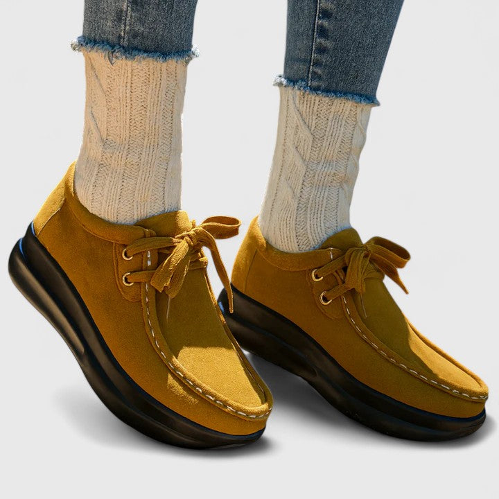Yellow lace-up orthopedic shoe with suede upper and thick dark sole.