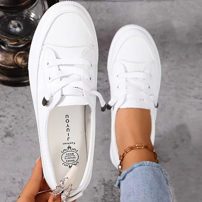 White low-top lace-up sneakers, rounded toe, visible laces and rubber tread sole