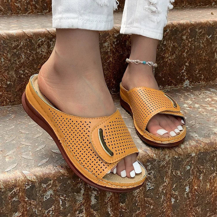 Perforated slide sandals in tan with wide toe strap and cushioned sole
