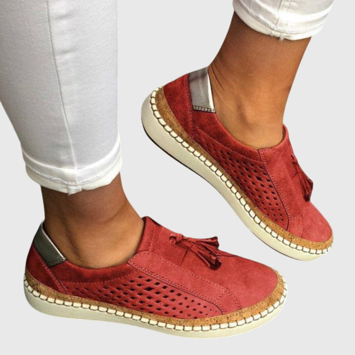 Red orthopedic slip-on shoes with tassel detail and perforated upper, cushioned outsole