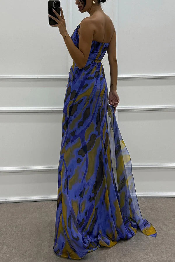 Back view of blue strapless maxi dress with abstract print and long flowing skirt panels