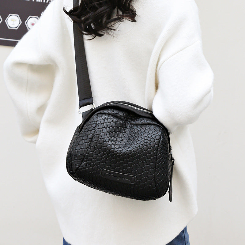 Black woven-texture shell crossbody bag with zip top and front logo patch