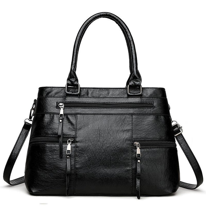 Black leather women’s tote bag with double top handles, front zip pocket and detachable strap
