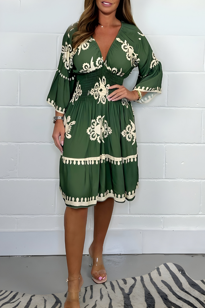 Dark green knee-length dress with white embroidered florals and tassel-trim hem