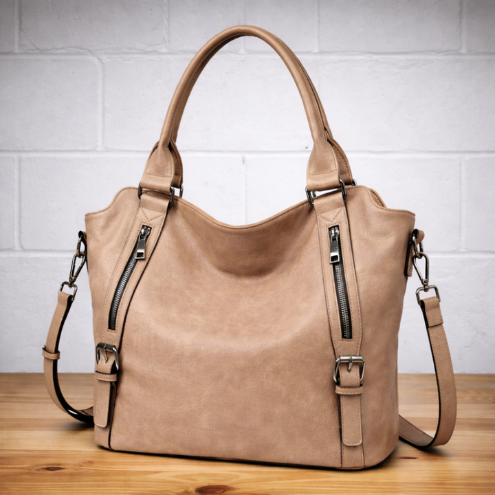 Light brown leather hobo tote bag with two top handles, two zip compartments, and strap