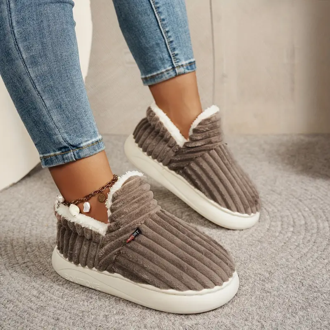 Brown corduroy-style comfort slippers with white faux-fur trim and striped upper