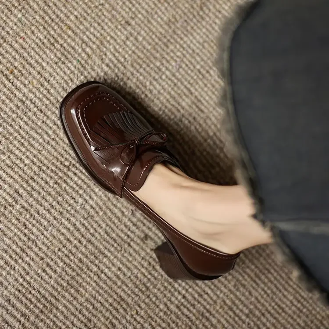 Brown loafer pumps with tassel bow detail and scalloped toe trim