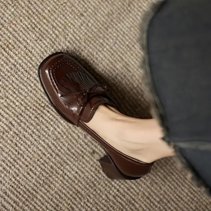 Brown loafer pumps with tassel bow detail and scalloped toe trim