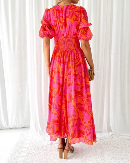Back view of red and pink patterned maxi dress with puff sleeves and elastic waist