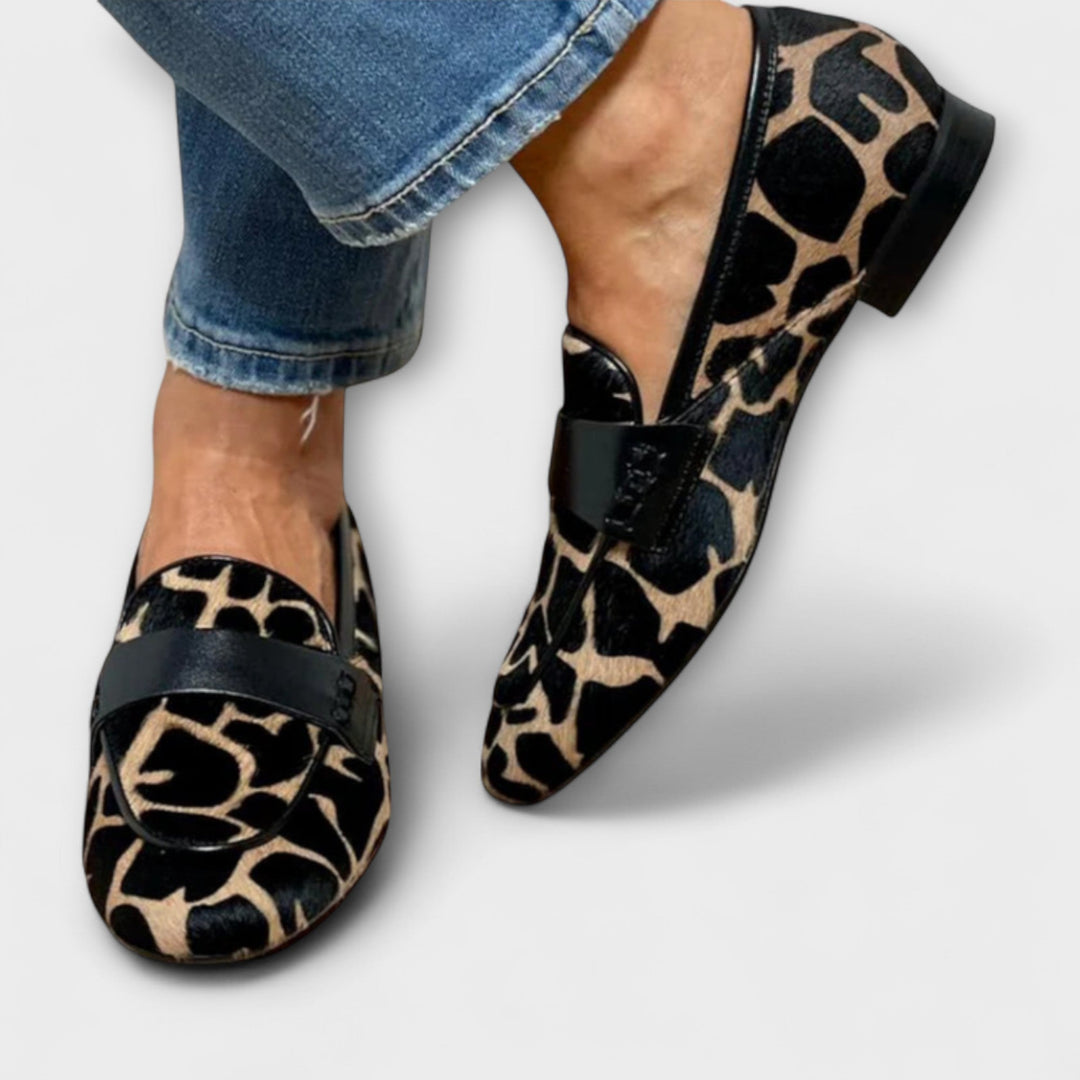 Leopard-print slip-on slippers with black strap and pointed toe, low profile.