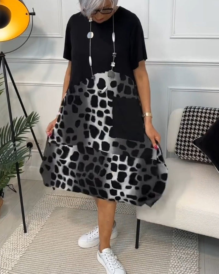 Women's black midi dress with leopard print panels, short sleeves, flared skirt