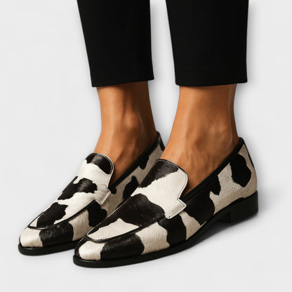Contemporary moccasins with black-and-white cow print leather, side view, low sole