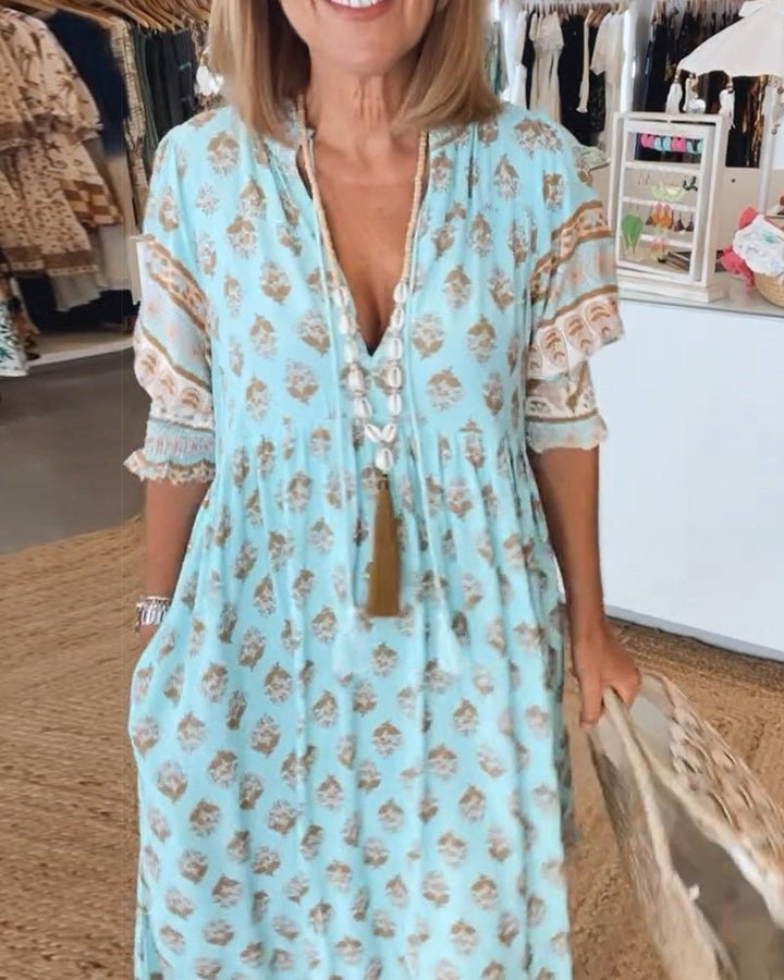 Blue floral V-neck tiered dress with tasseled drawstring detail, front view